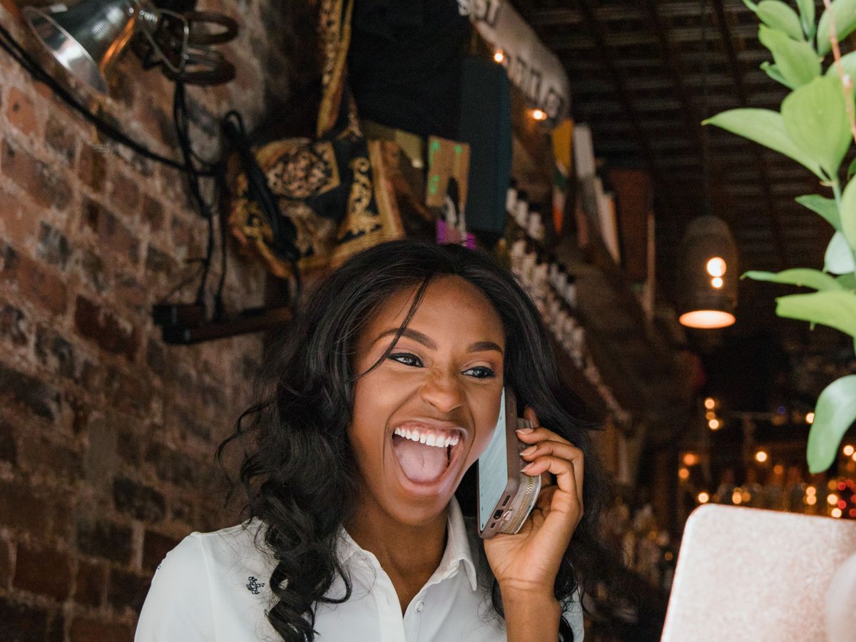 A small-business owner celebrating good news on the phone.